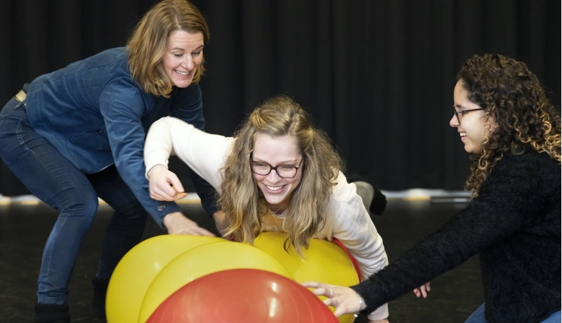 3 studenten van de han master vaktherapie psychomotorische therapie doen een oefening met skippyballen in de gymzaal
