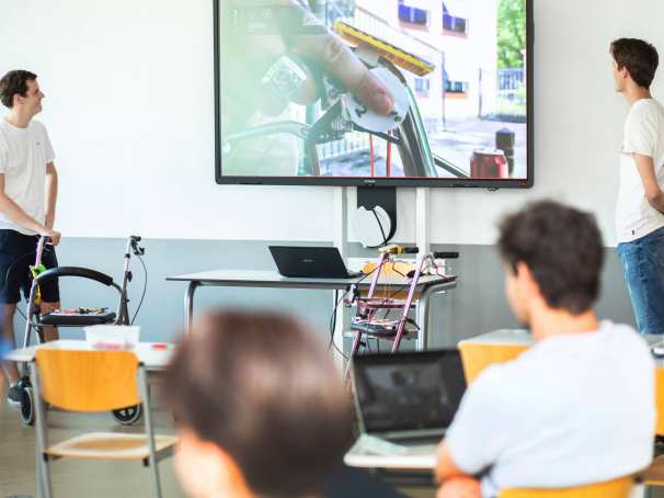 Studenten kijken in de klas naar een presentatie van hun project