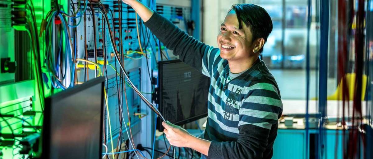 Lachende man test de installatie van de smart grid in de WATTS simulatieruimte.
