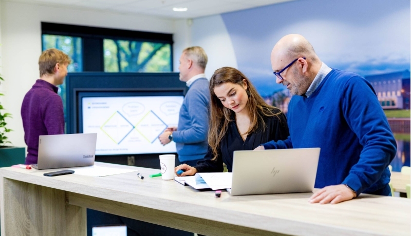 Studenten van de master Business Sales in overleg, samenwerken op laptop. 