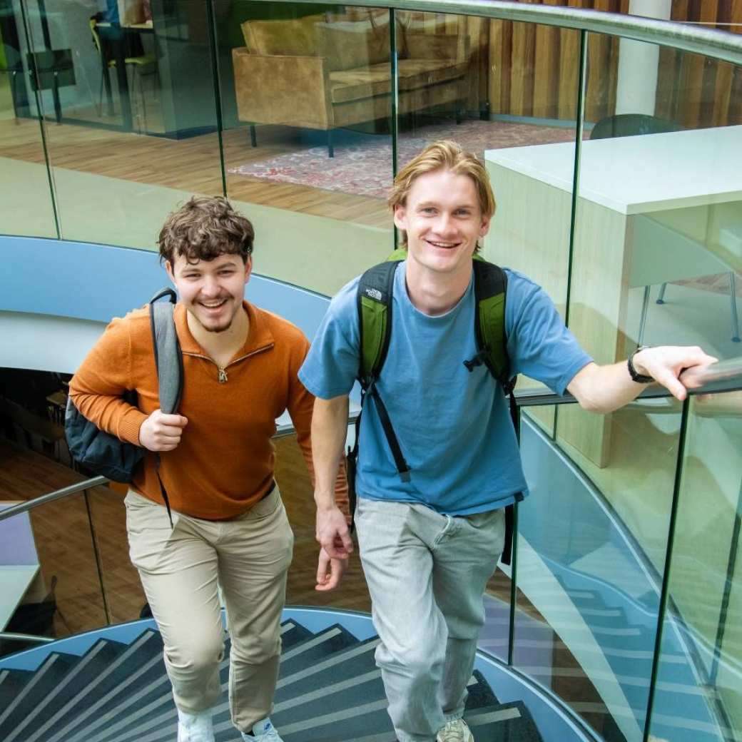 Studenten opleiding Ad Logistiek voltijd lopen lachend de trap op