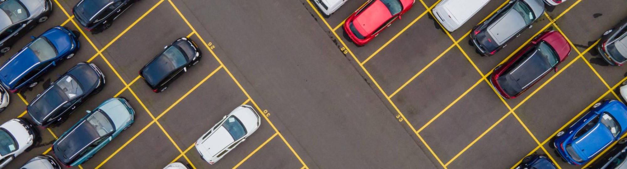 Bovenaanzicht van grote partij auto's die op een parkeerplaats klaarstaan om ete verschepen.
