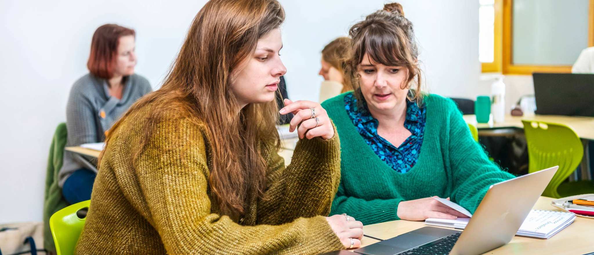 Twee studenten Leraar Engels werken samen op één laptop.
