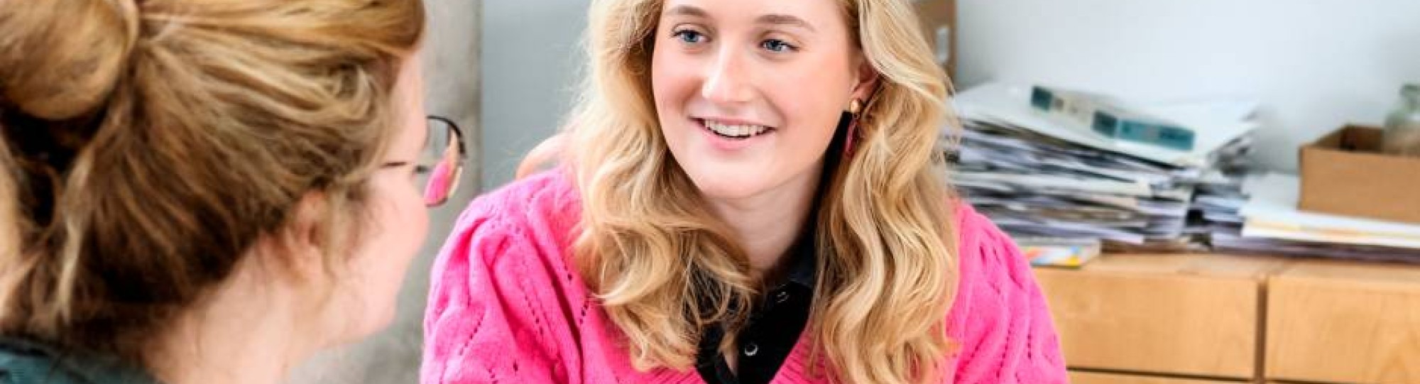 Fotoshoot maakdagen beeldende vorming 2022. Docente in gesprek met studente die bezig is met een portrettekening