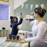 Docente geeft een high five aan een meisje.