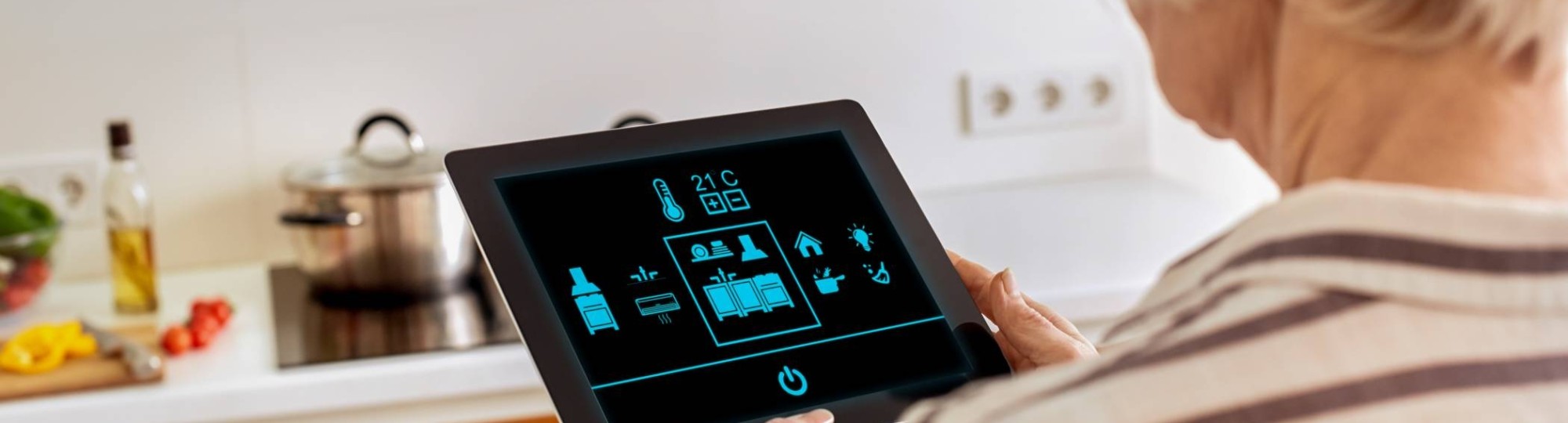 Oudere dame werkt met een tablet om op een innovatieve manier haar woning te bedienen.