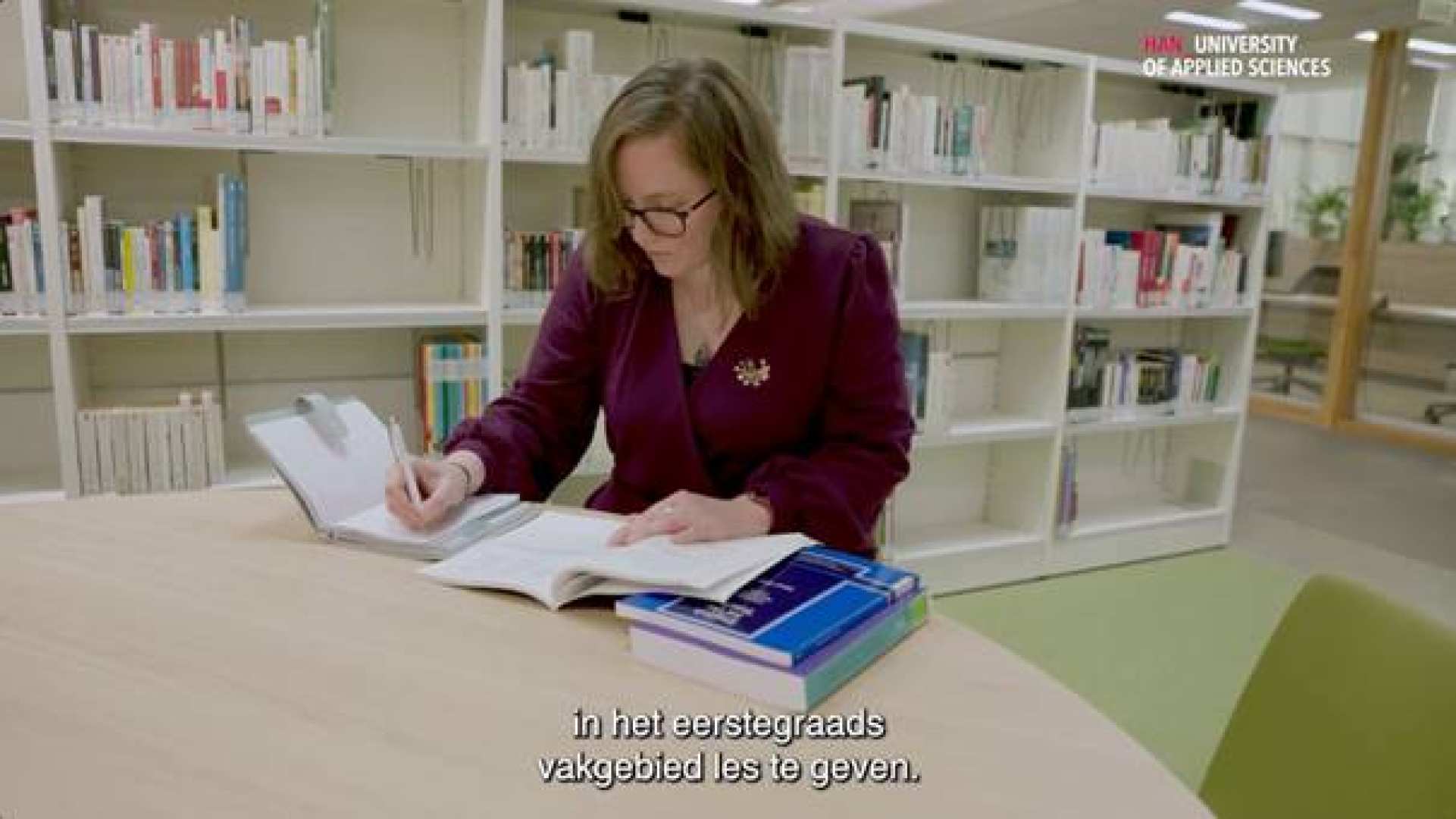 MA student leaar Engels zit in bibliotheek en schrijft.
