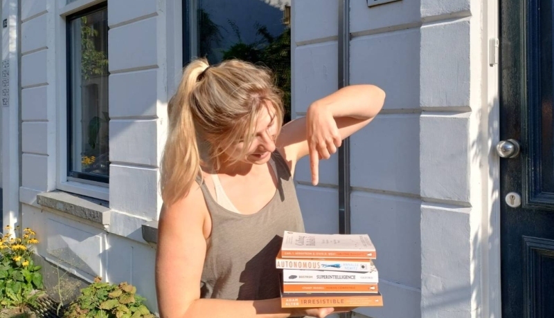 Foto van Onna Nieuwenhuis met AI-boeken voor promotie van de AI Book Swap 