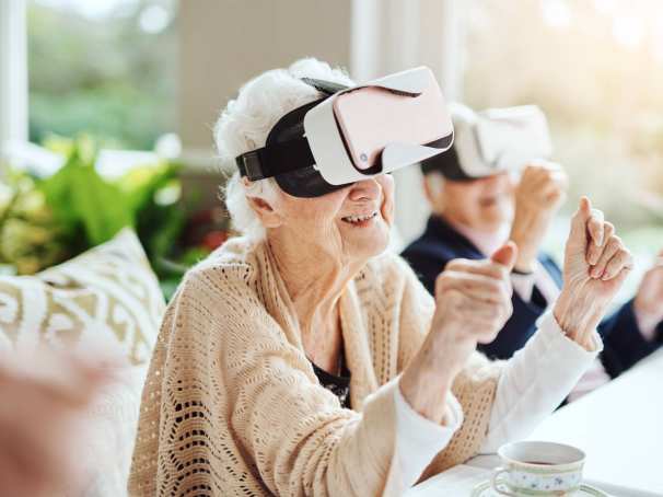 oudere vrouw met vr bril zit aan tafel