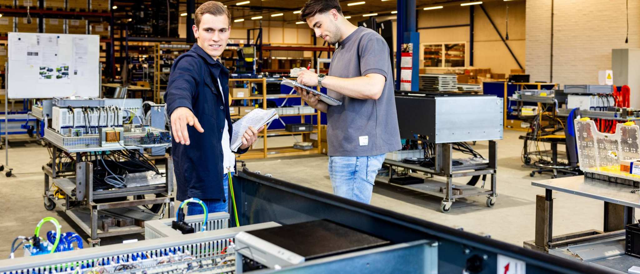Technische Bedrijfskunde studenten werken samen op werkvloer.
