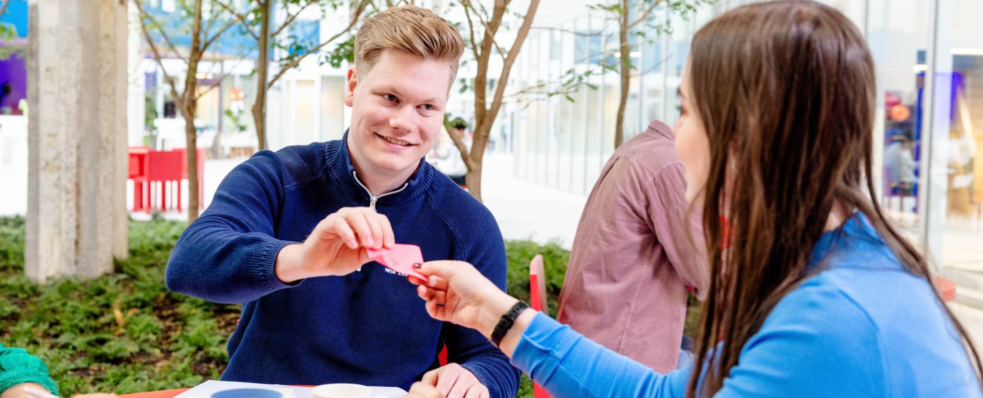 Cursist zomeropfriscursus student geeft briefje aan student