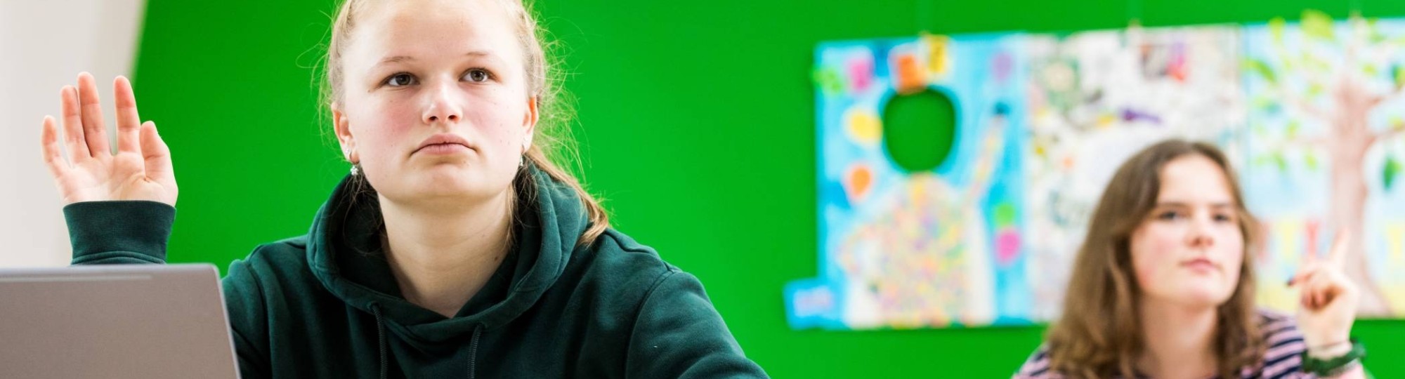 Close Up ALPO student met een groene hoodie met hand omhoog