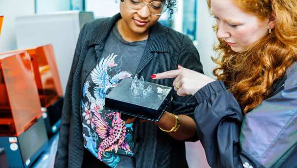 IPO-student Elena wijst naar het 3d geprinte product van student Tayisha in Fab Lab bij Industrieel Product Ontwerpen