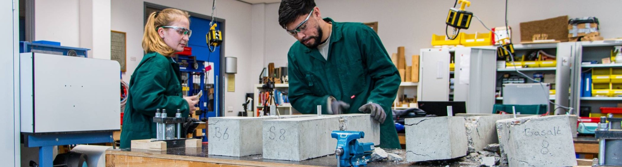 Omscholers naar bouwkunde testen beton in het betonlab.