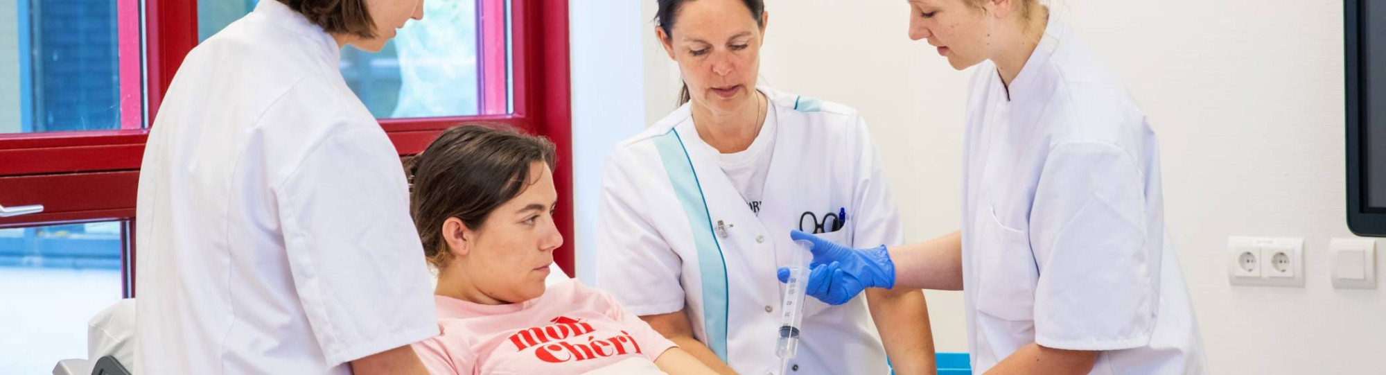 Studenten en docent Verpleegkunde bezig tijdens praktijkles