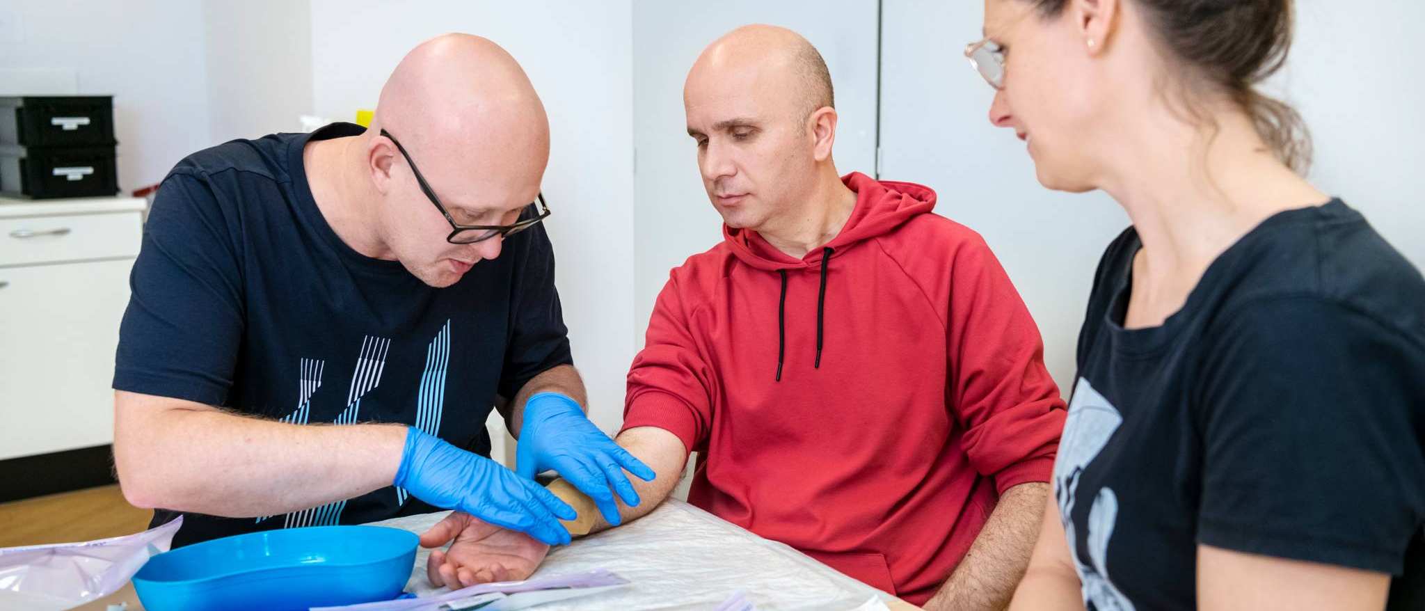 3 studenten oefenen wondverzorging tijdens les Verpleegkunde deeltijd
