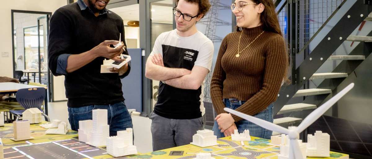 Studenten van de Master Engineering Systems Sustainable Energy en een docent bij de Smart Grid-tafel