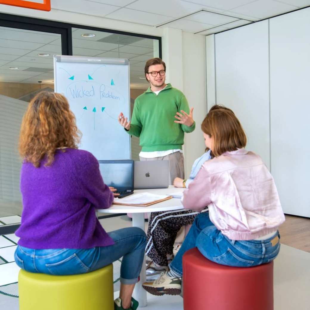 3 masterstudenten aan het werk in klaslokaal