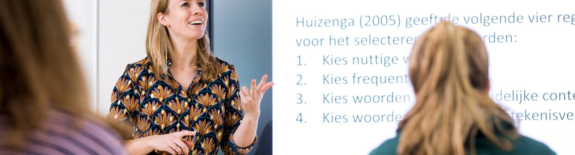 ALPO leraar staat voor de klas en telt op haar vingers