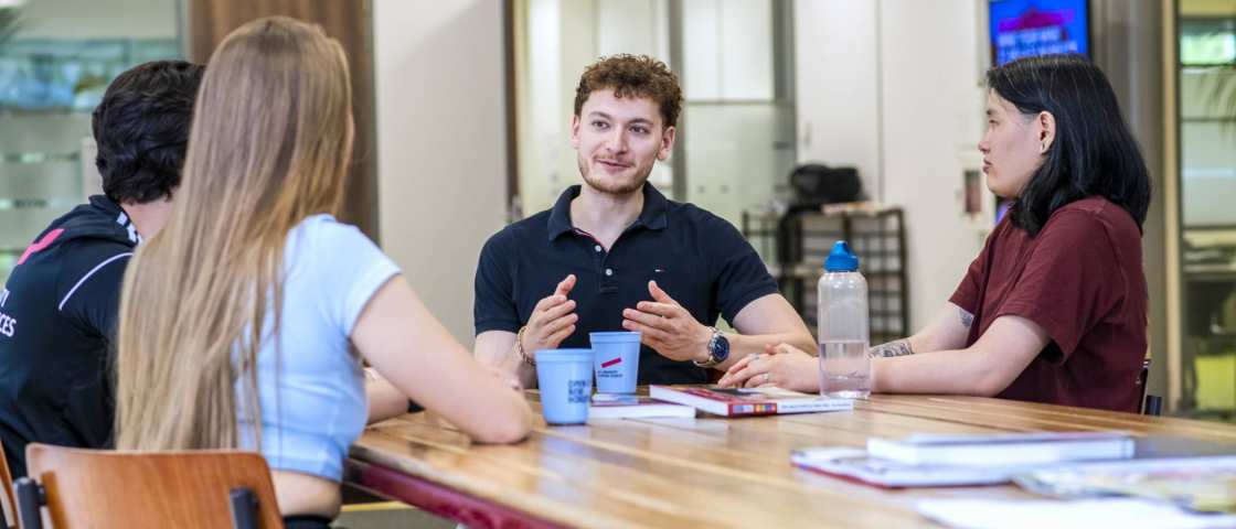 studenten kletsen met elkaar aan tafel op het Gymnasion