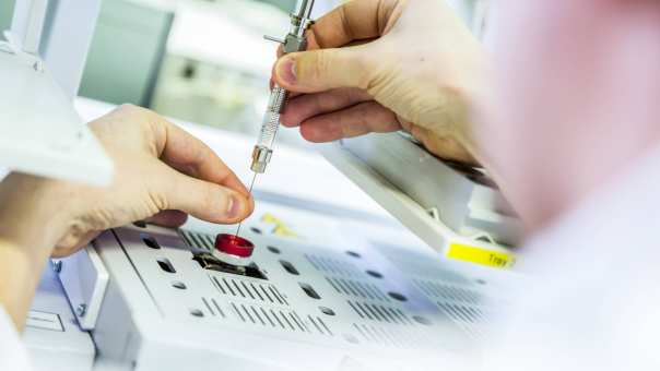 injectiespuit in machine met handen