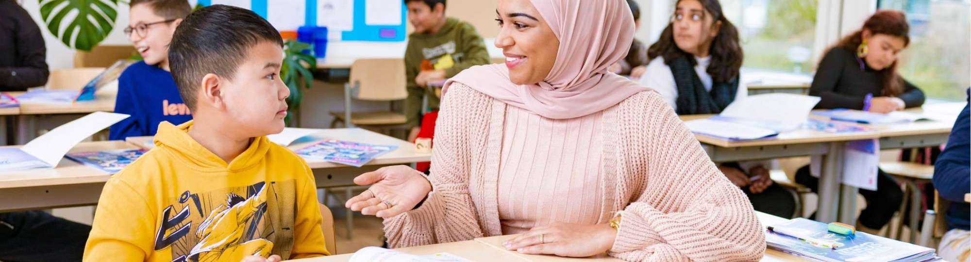 Groep 5,6,7 op de school Da Vince. De lerares zit naast de leerling aan de tafel. 