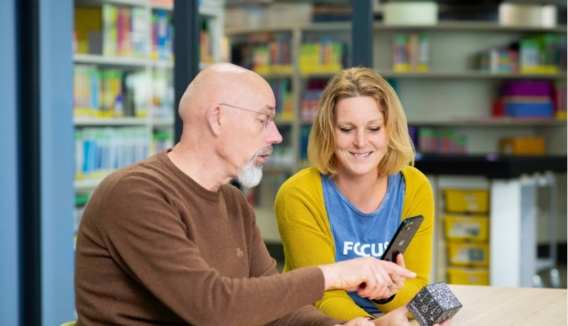 2 deeltijdstudenten overleggen in de bibliotheek.