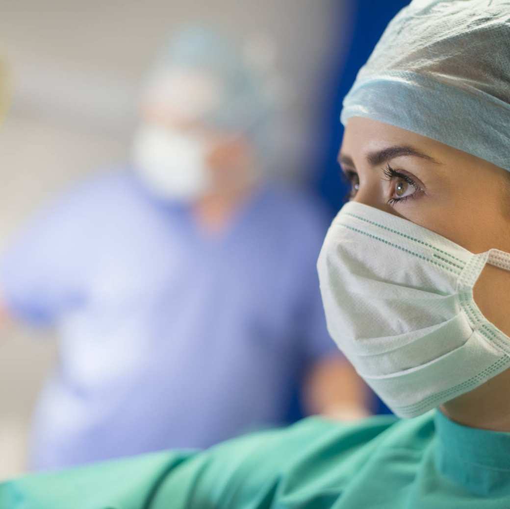 Vrouw op de operatiekamer met een mondkapje