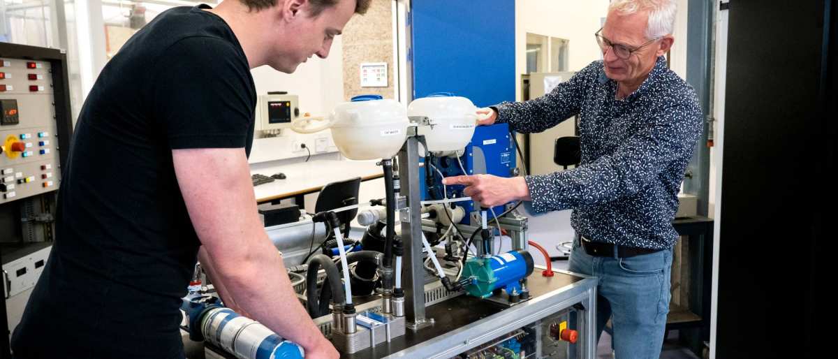 Een automotive docent en student werken samen aan de waterstoftafel.