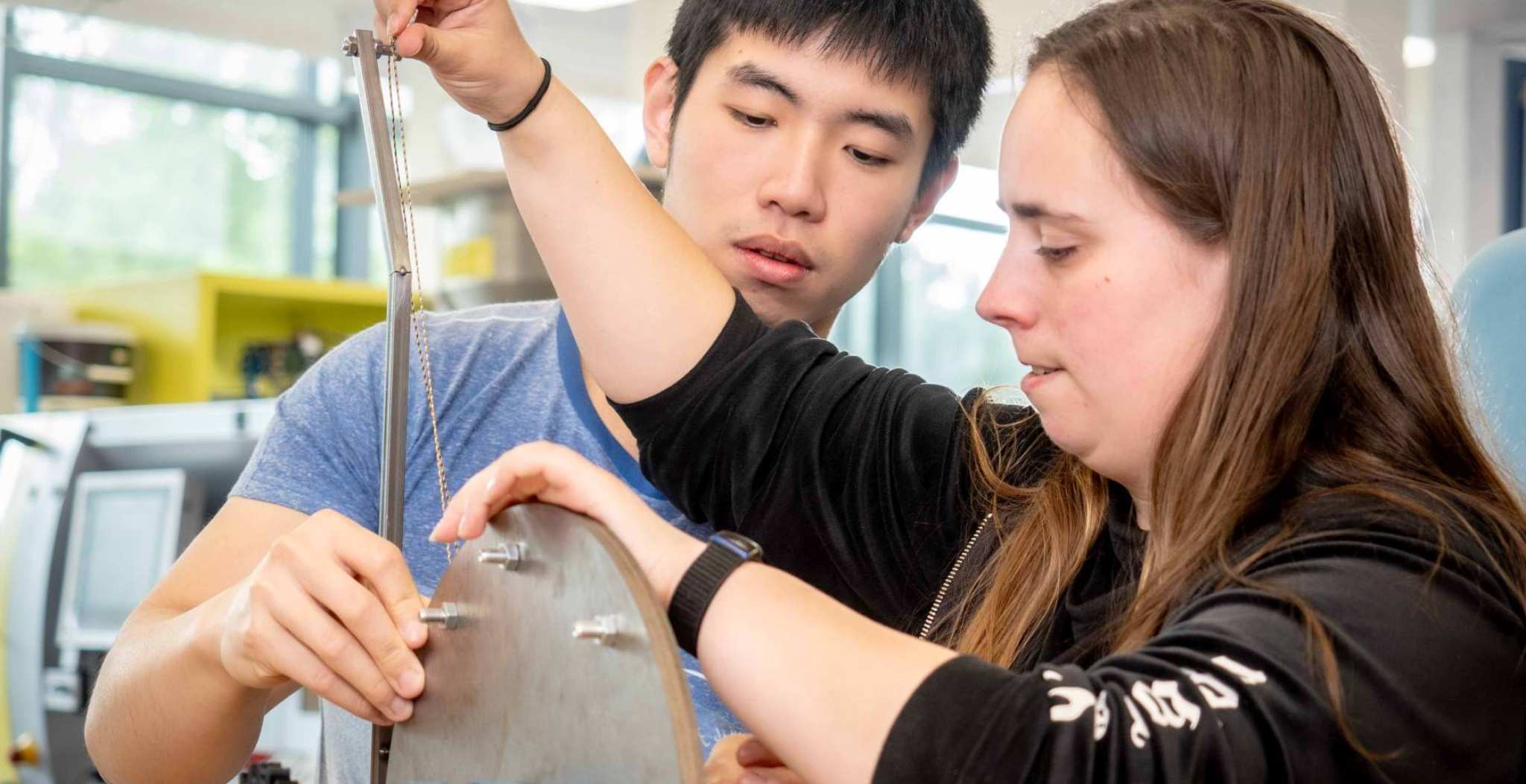 Twee studenten werktuigbouwkunde werken samen aan een kartrol.