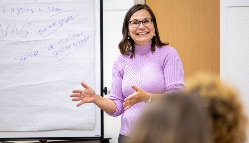 Ruth Pel staat voor een groep en vertelt over het lectoraat Wijkverpleging.