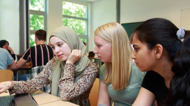 3 voltijdstudenten van de mastertrack Chemistry werken in de klas bij een laptop.