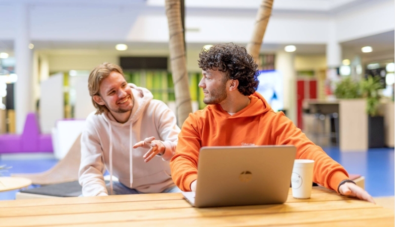 HAN Accountancy studenten in overleg achter laptop op de leslocatie in Nijmegen