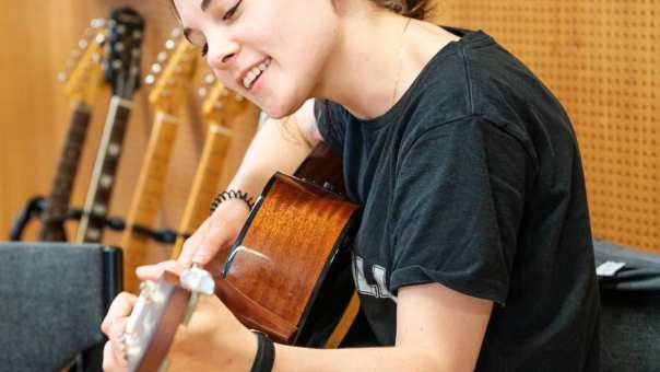 Student Vaktherapie maakt muziek op gitaar
