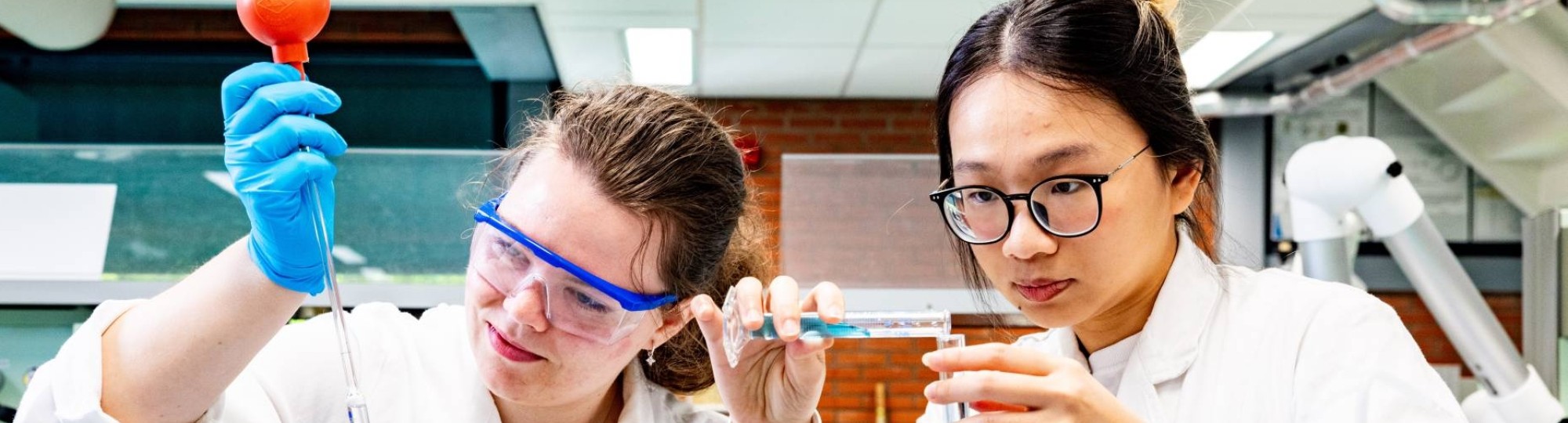 studenten pipetteren in het chemielab