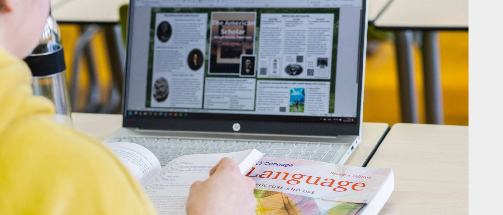 Foto Master Academie Educatie. Een masterstudent zit achter haar laptop met een boek opengeslagen in haar handen.