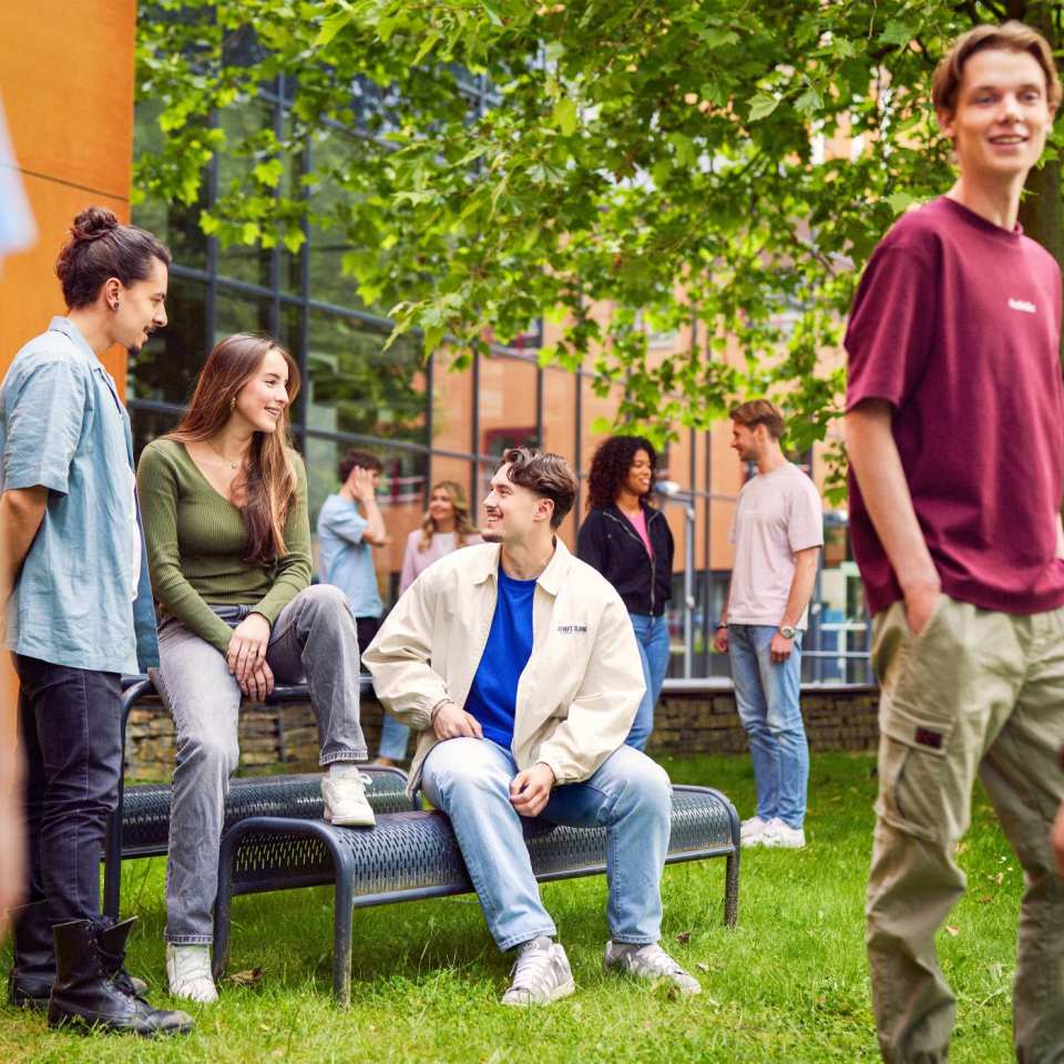 werving voltijd campagne, groepje studenten met blauwe blouse rondom een picnictafel in de binnentuin.
