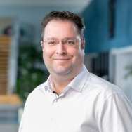 Chris Huijboom, werkzaam bij Automotive. Lichte blouse, brildragend