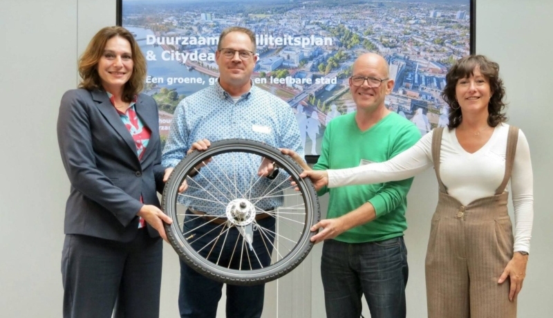 Fotomoment waarbij Nermina Kundić, Gerrit Averesch, Hans Schreuder en Monique Verhoef symbolisch een fietswiel vasthouden, daarmee is de ondersteuning van de City Deal bekrachtigd.