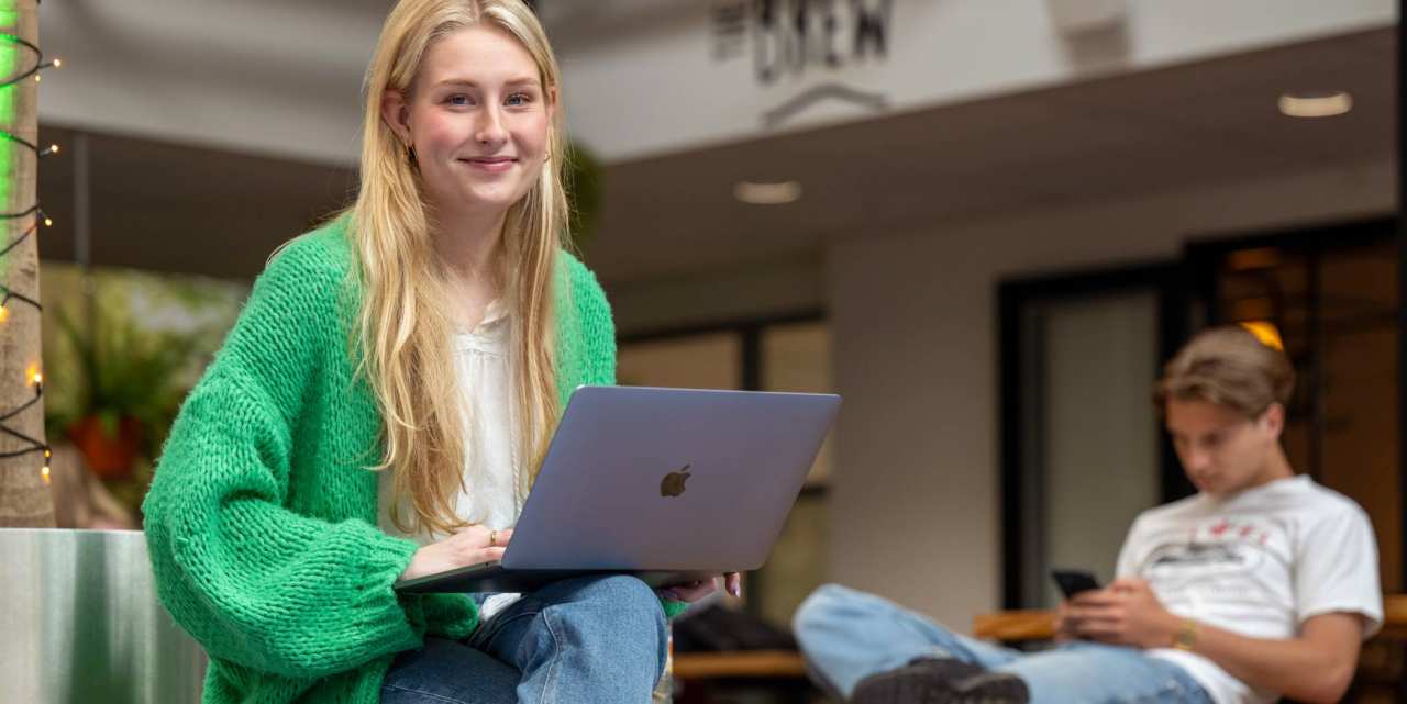 Student met laptop gaat aanmelden voor een studie