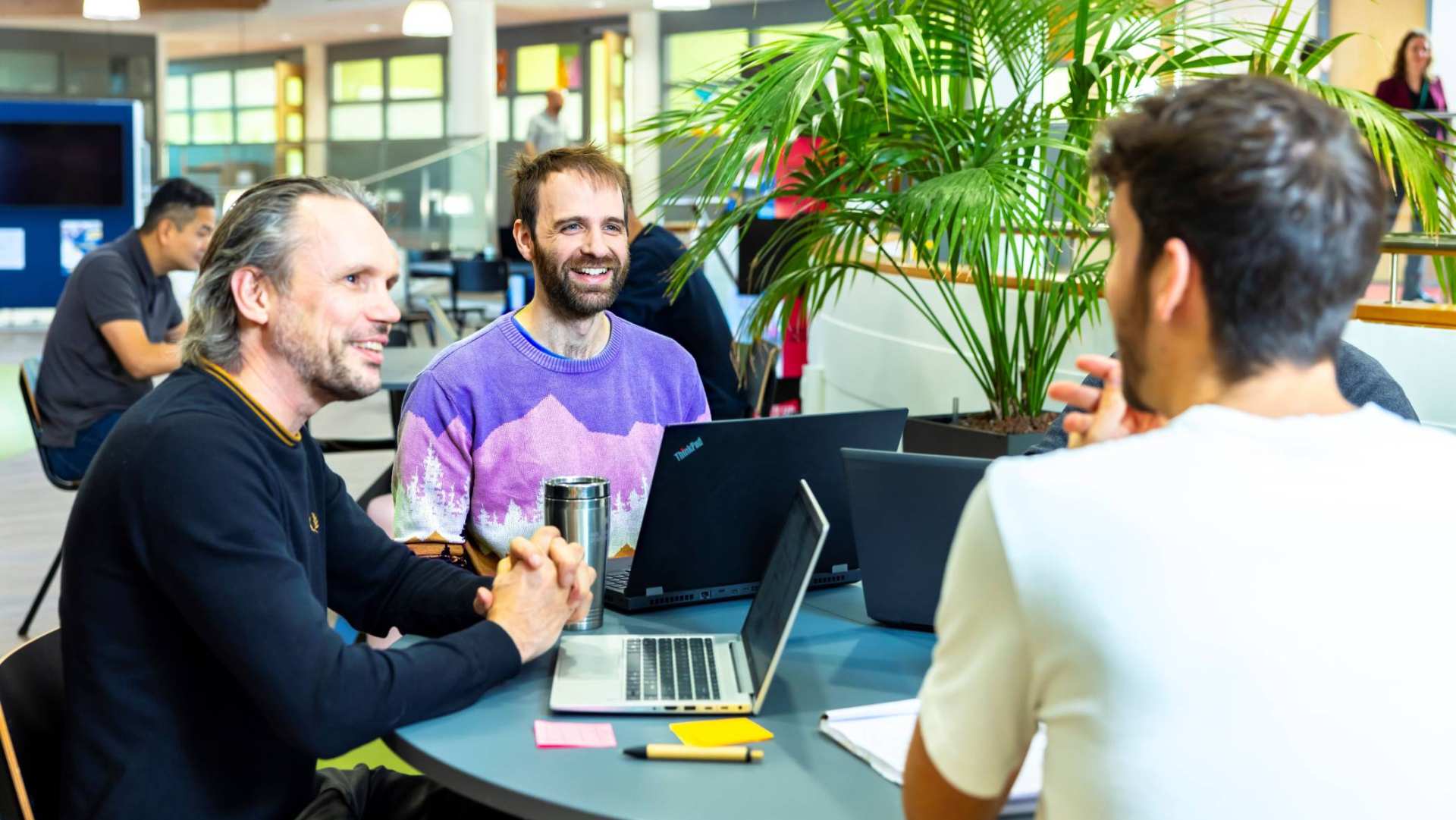 Master Applied Data Science studenten krijgen uitleg van docent en zitten aan ronde tafel met de laptops open