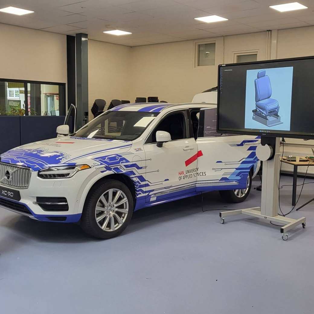 Volvo XC90 die opvallend is gewrapt in een passende lichtblauwe kleurstelling en bijpassend HAN design.
Deze Volvo XC90 wordt o.a. gebruikt voor het project HUBRIS (HUman-like Behaviour of Robotic In-vehicle Systems). Hierin zal de stoel van de bijrijder aangepast worden om als een rijsimulator de passagier het gevoel te geven dat deze echt meerijdt. Met een VR-bril op zal de testpersoon virtueel de A50 van Arnhem naar Apeldoorn (mee)rijden. Soms bestuurt door een normale 'autopilot', soms door een 'robotbestuurder' die meer mensachtig gedrag vertoont.
Het doel is uit te vinden of onze mensachtige robot voor de passagier fijner aanvoelt dan de standaardsystemen.