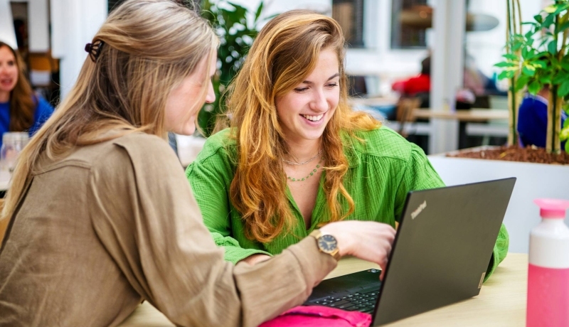 Studenten studeren samen en kijken naar een laptop.