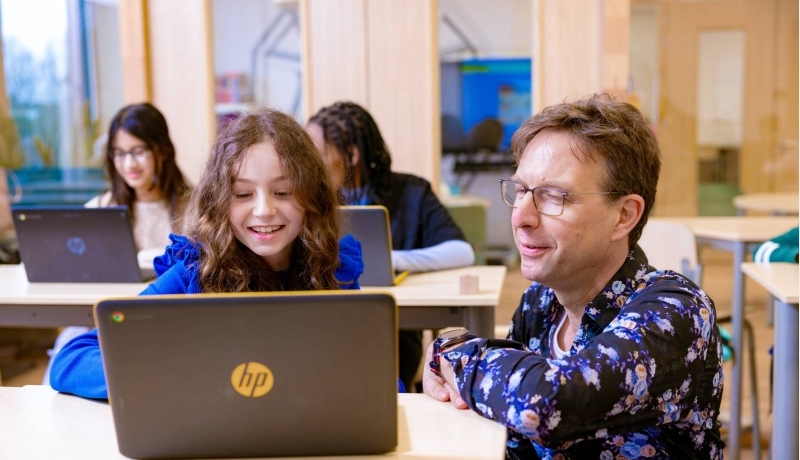 Pabo-student deeltijd bij een tafel kinderen in de klas.