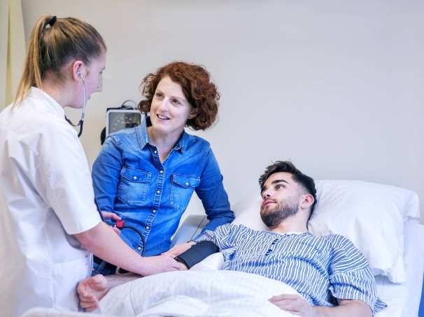 Voltijd student Verpleegkunde en docent aan het bed van patiënt meten bloeddruk-2