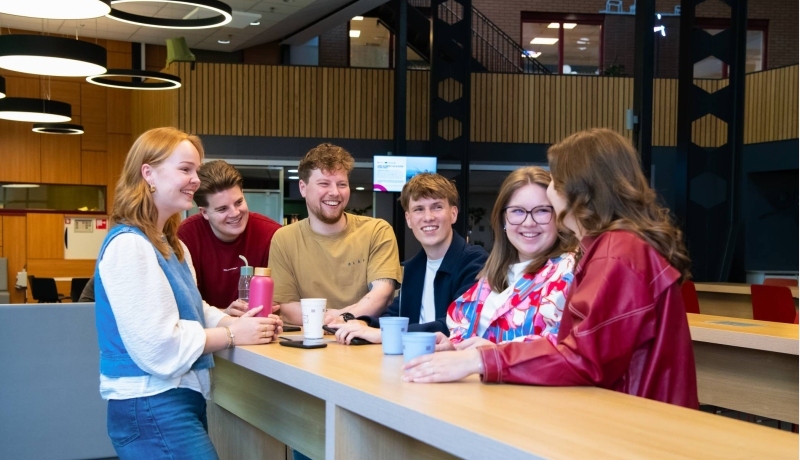 Studenten Ergotherapie lopen in de gang op de HAN campus in Nijmegen en kijken lachend naar elkaar