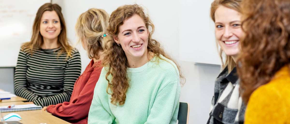 ALLEEN VOOR DE MANP | Lachende masterstudenten overleggen samen tijdens een klassikale les onderzoek op de HAN in Nijmegen.