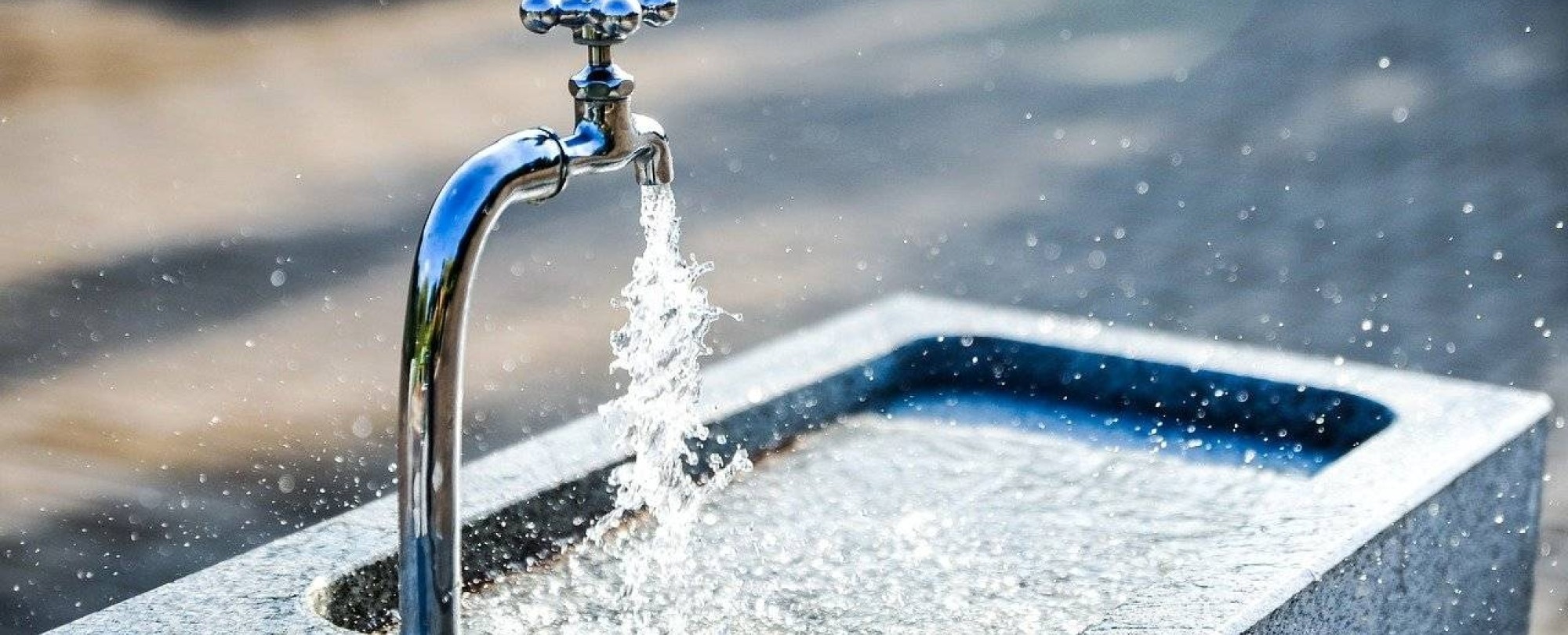 kraan met lopend water in een klein fonteintje buiten