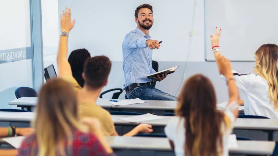 onderwijs en opvoeding, leerlingen steken hand op, docent wijst leerling aan
