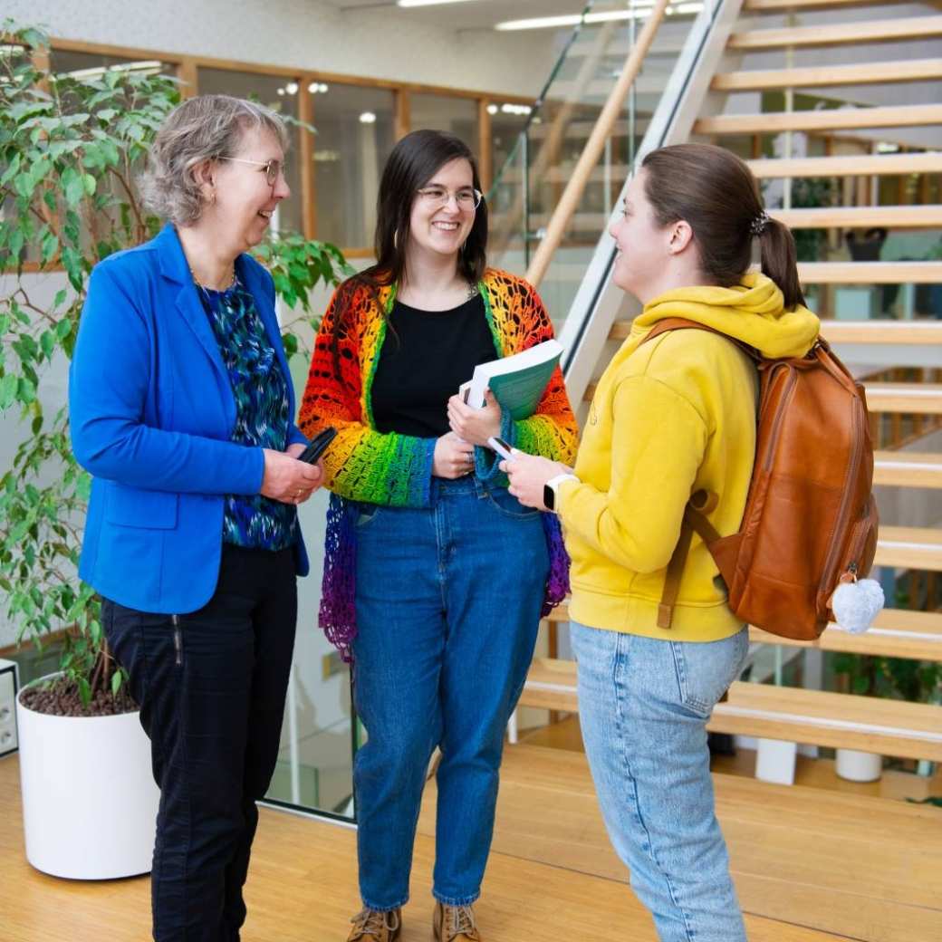 Foto Master Academie Educatie. 3 masterstudenten staan te praten voor de gang op Kapittelweg 35, Nijmegen.